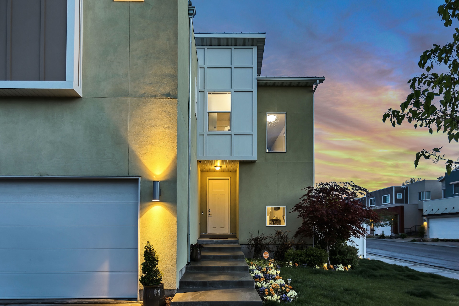 Outdoor lamps glowing on the exterior of a modern building at dusk. Image by Unsplash