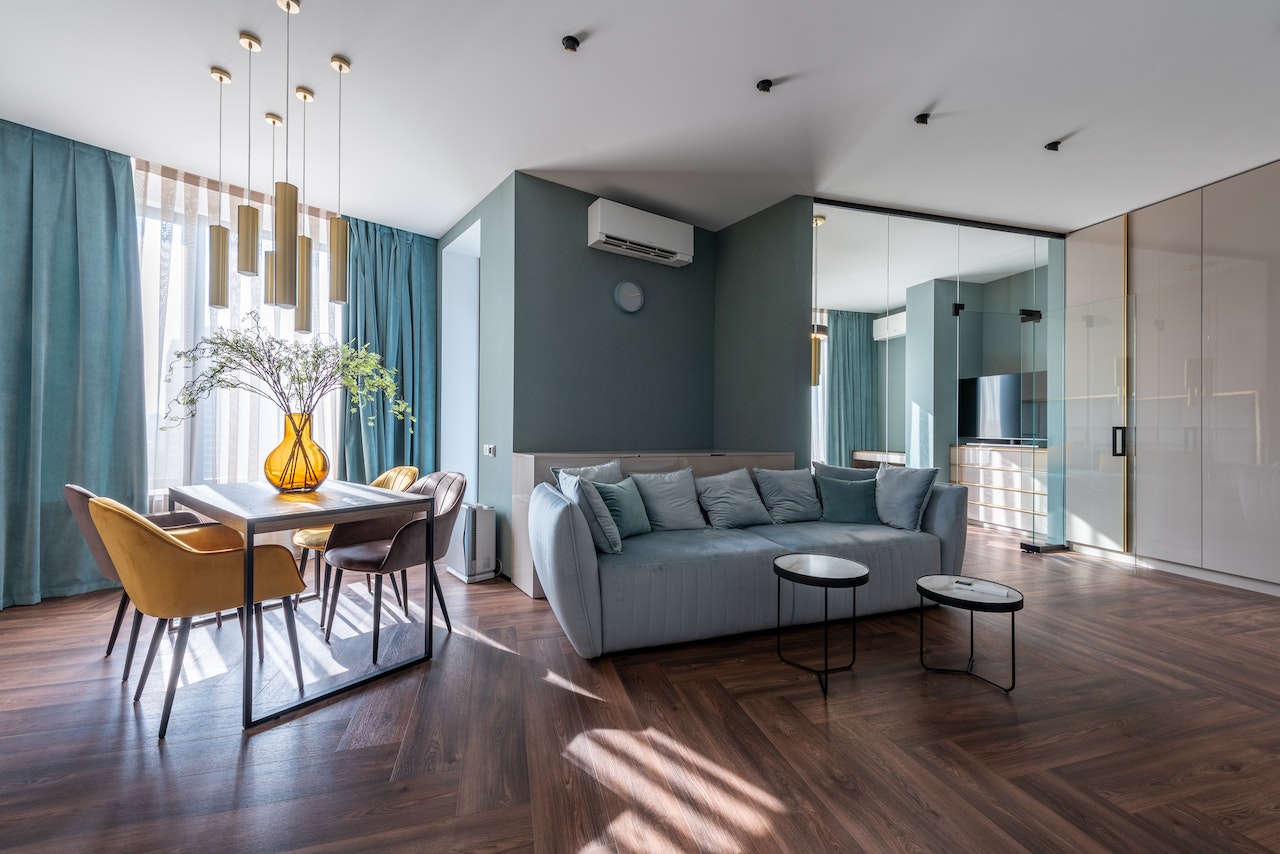 livingroom, diningroom, wood floors, sofa, table and four chairs, green walls, green curtains