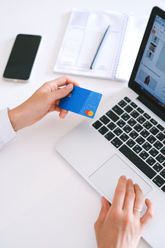 Person at a laptop with a credit card. Image by Pexels
