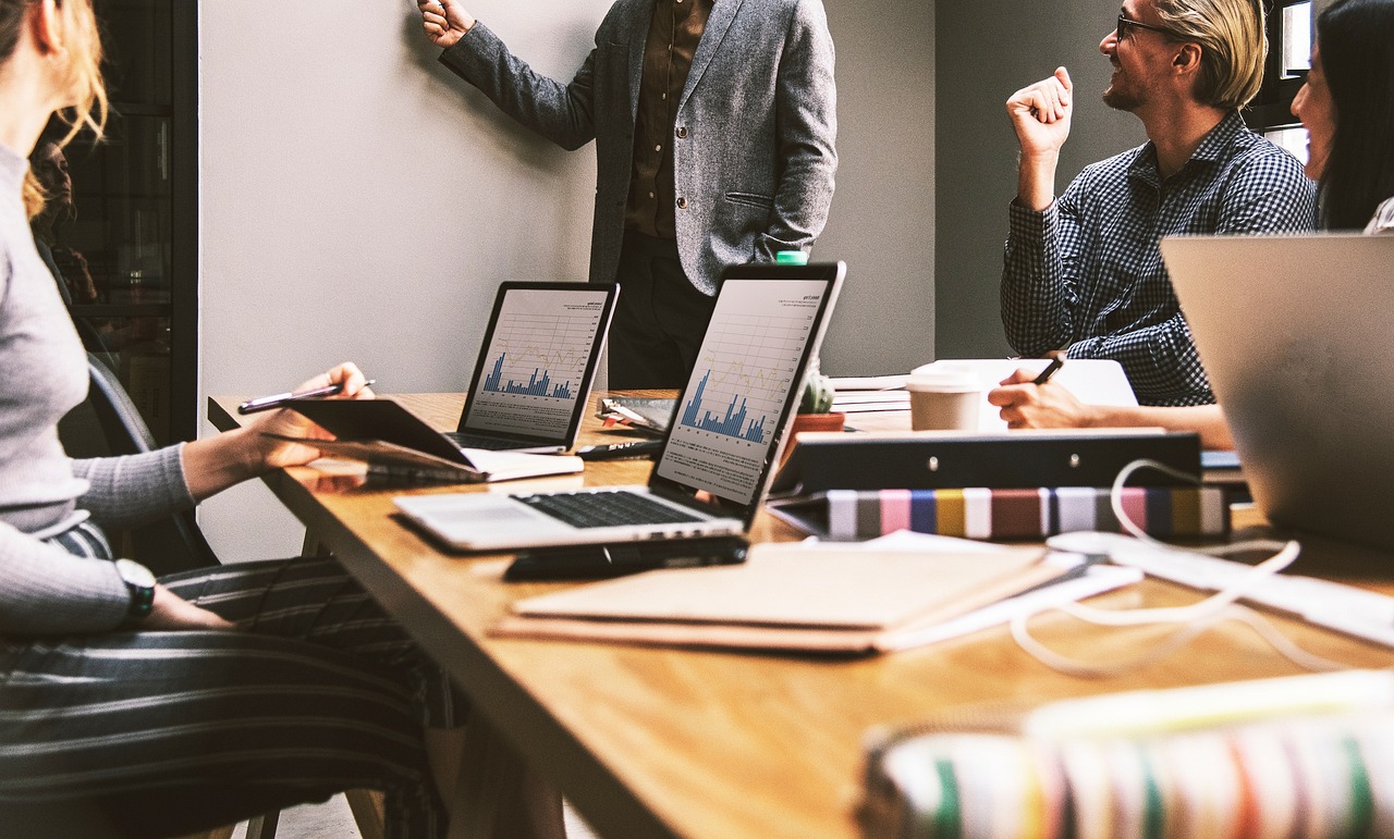 People in a meeting, laptops on a table. Image by Pixabay