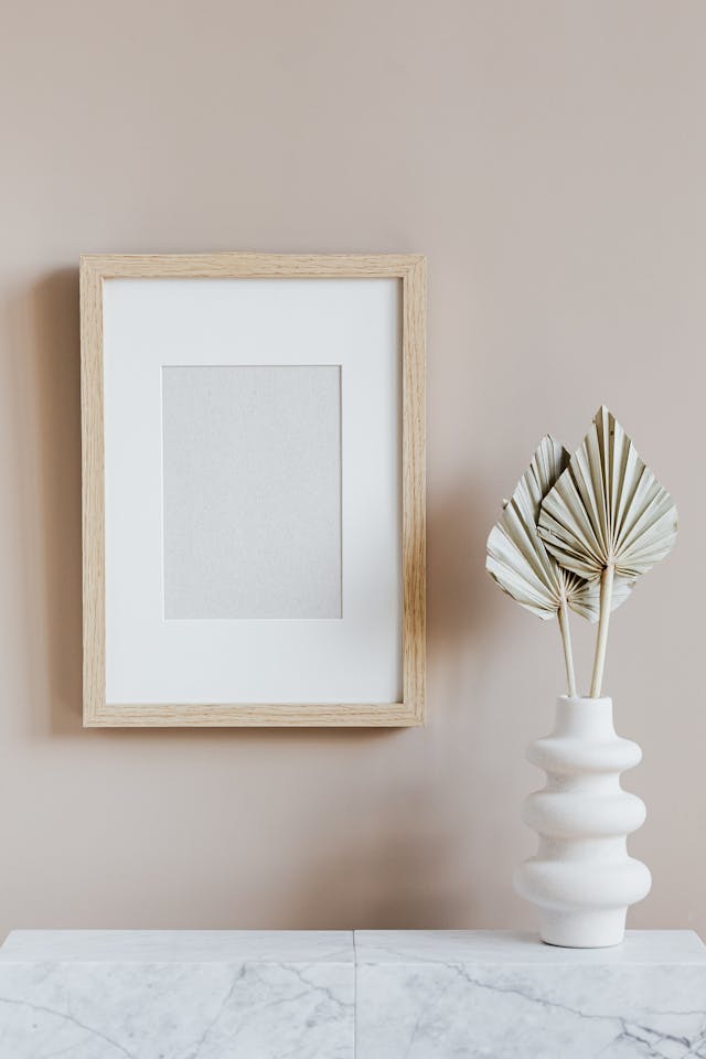 Empty picture frame mounted on a wall. Image by Pexels