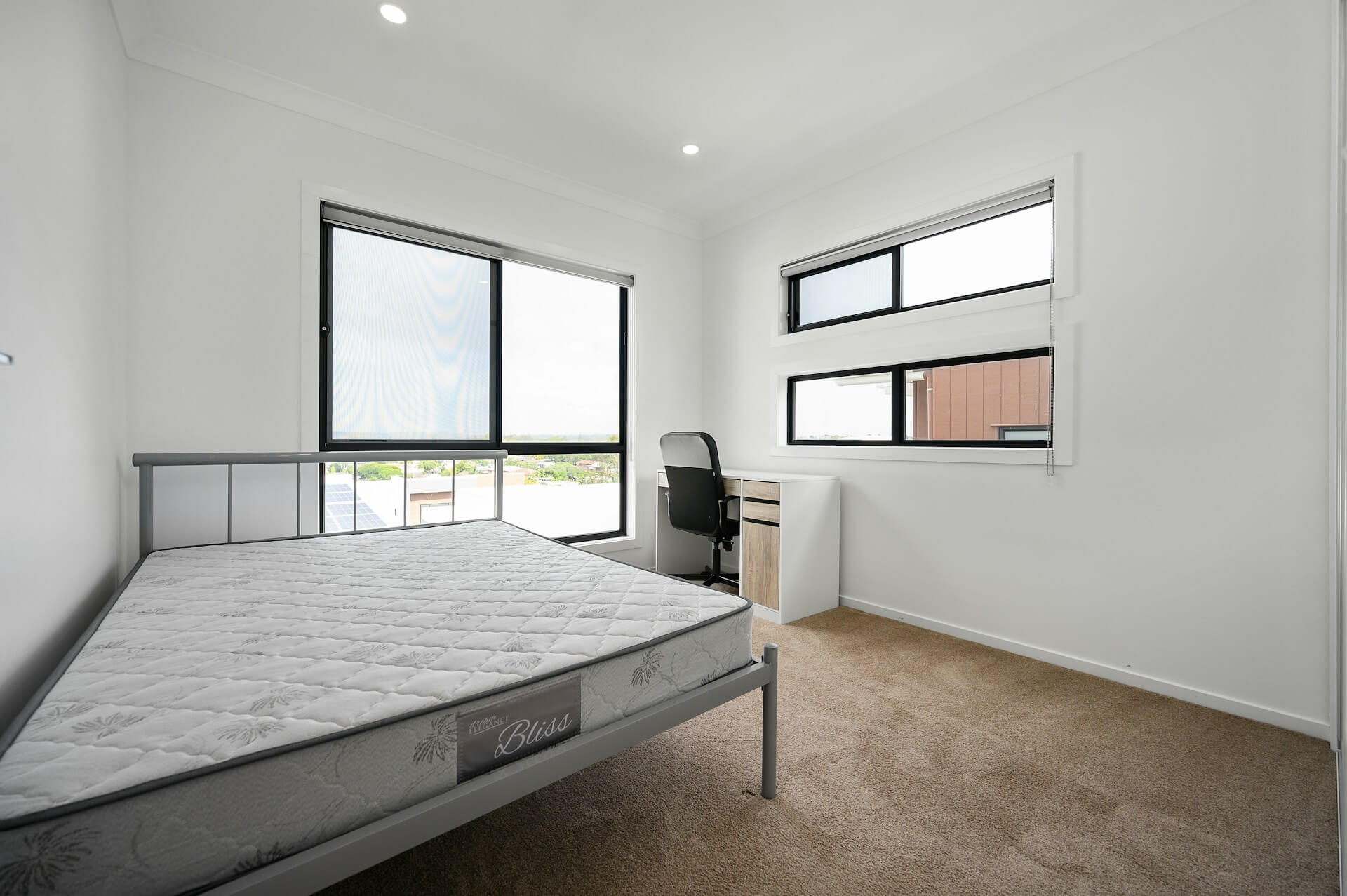 Spacious bredroom with grey curtains. Image by Pexels