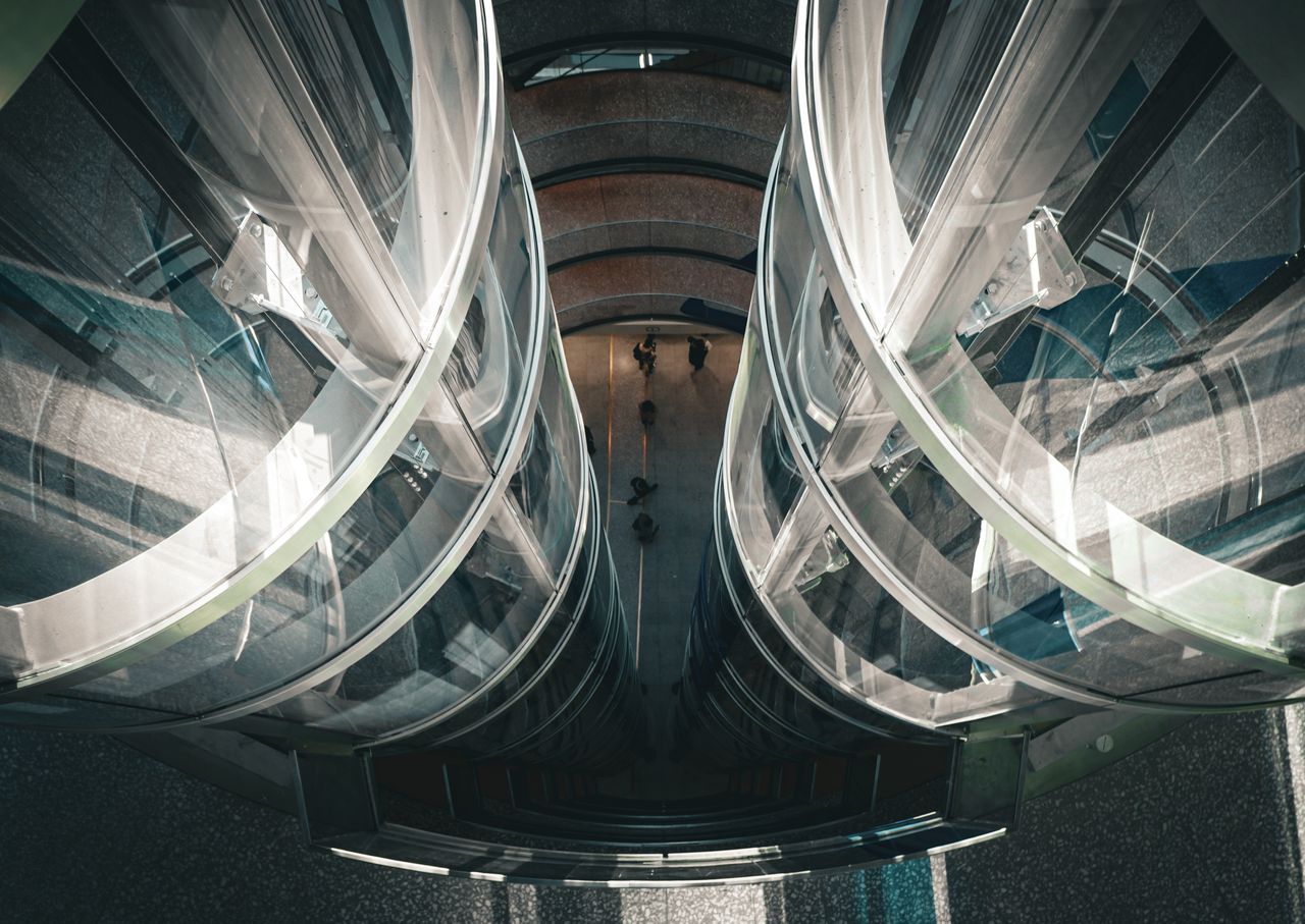 Futuristic glass elevator shaft viewed from above. Image by Pexels