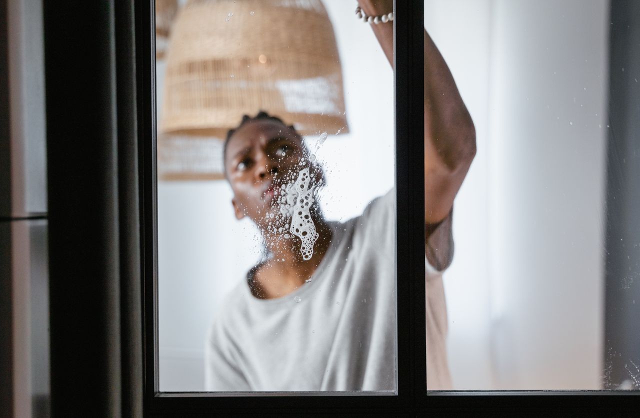 Person washing a window. Image by Pexels