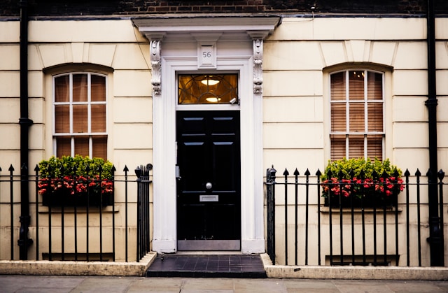 White house with black steel barriacde, plant boxes. Image by Unsplash