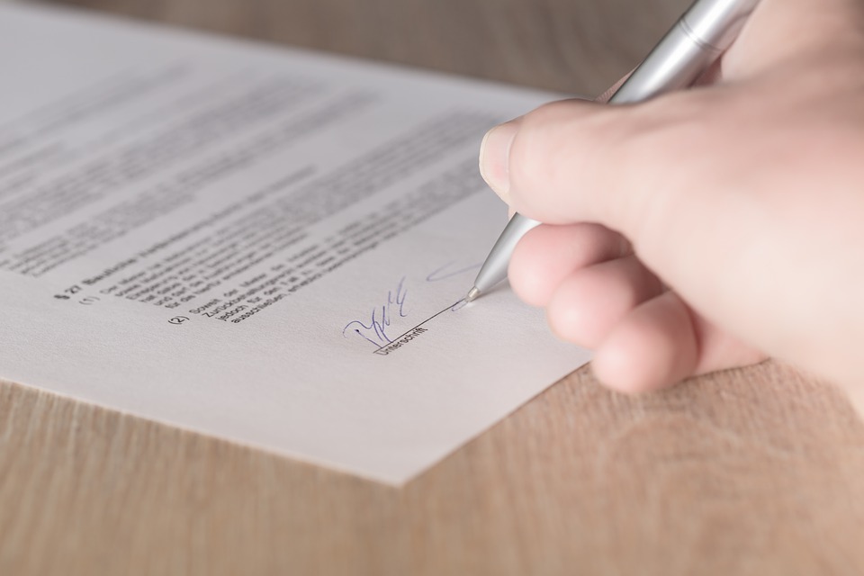 Person signing a paper