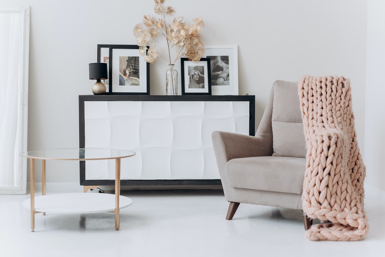 pictures in frames, dried flowers, chait and a glass table