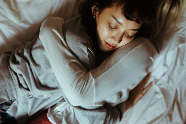 Couple embracing comfortably in a bed within a well-organized bedroom representing the contentment that comes from a decluttered home