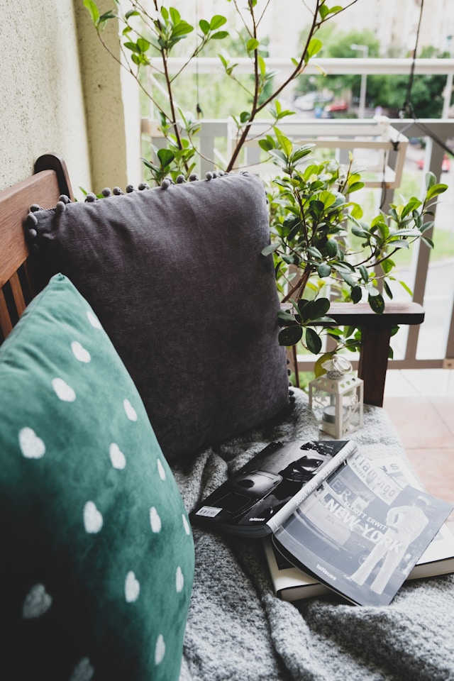 Cozy balcony with furniture, plants and a book. Imae by Unsplash