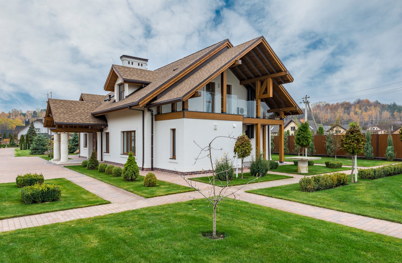 Suburban residential villa with trees and bushes, green lawn. Image by Pexels