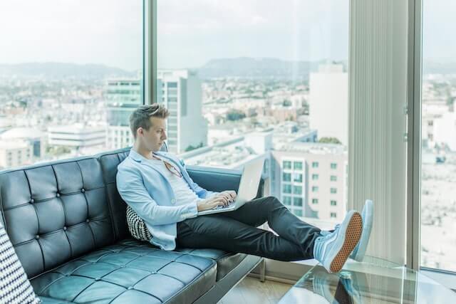 person sitting on a sofa with a laptop