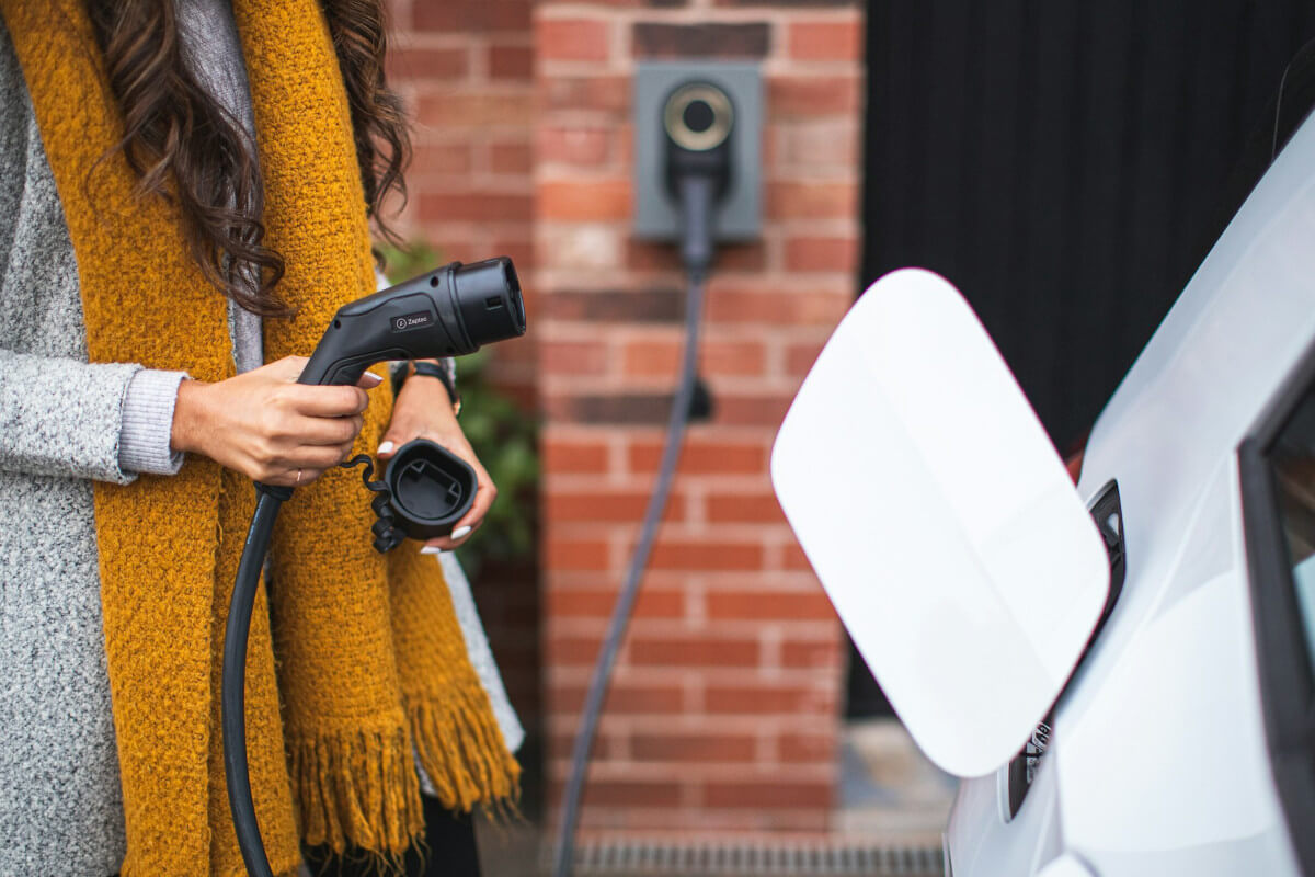 A person using an EV charger. Image by Unsplash