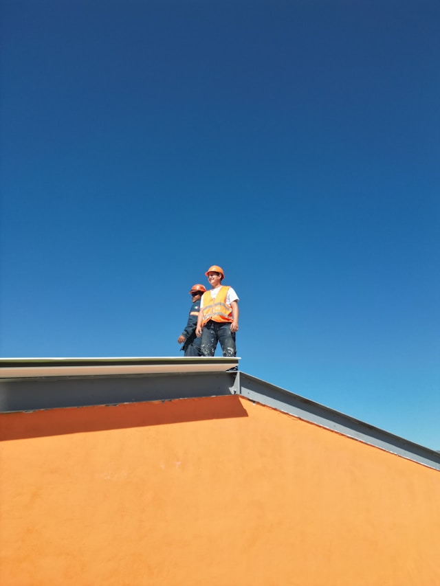 2 people on top of a roof. Image by Unsplash