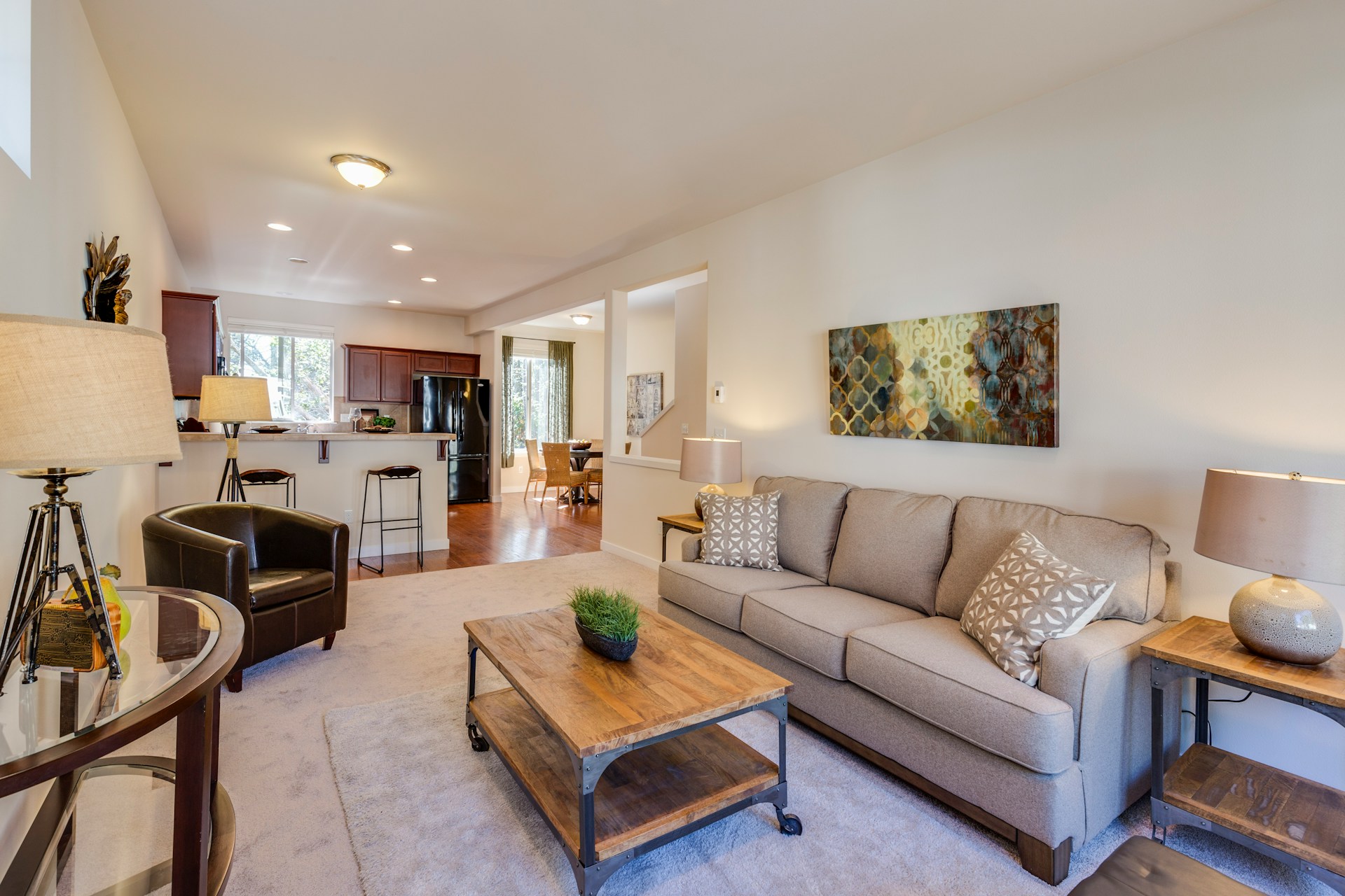 Interior of a modern living room with a couch, chairs, and large windows. Image by Unsplash