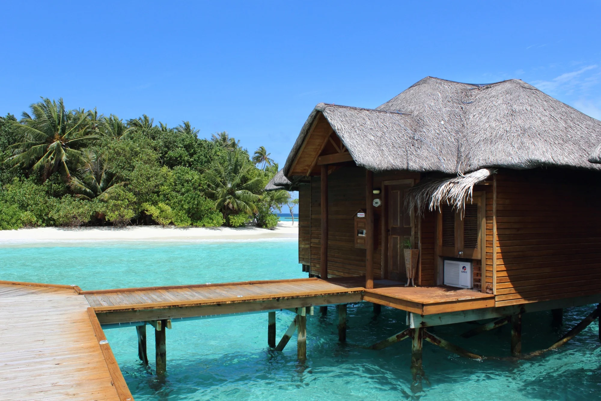 House oon the water, blue sky, blue, clear water.