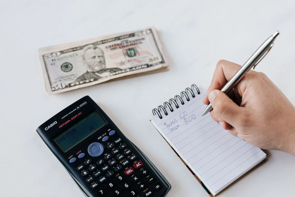 Money, calculator, notebook, pen