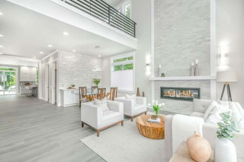 open space floorplan. Livingroom with white furniture, fireplace.